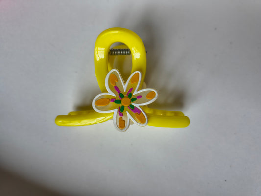 Stylish yellow claw clip with colorful floral charm.